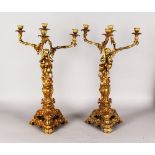 A GOOD PAIR OF GILT ORMOLU FOUR LIGHT CANDELABRA, with cupids holding scrolling branches, with