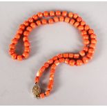 A STRING OF CORAL BEADS with Chinese gold clasp.