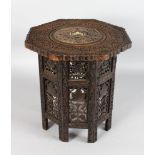 AN INDIAN CARVED COLLAPSIBLE TABLE inlaid with ivory. 16ins high.