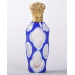 A GOOD BOHEMIAN BLUE AND WHITE OVERLAY GLASS PERFUME BOTTLE with gilt metal cap, 8.5cms long.