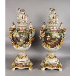 A PAIR OF DRESDEN STYLE PORCELAIN VASES, COVERS AND STANDS, decorated with romantic landscape scenes
