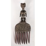 A CARVED TRIBAL COMB. 9.5ins.