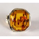 A SILVER AND AMBER RING.