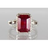 A 14K WHITE GOLD AND DIAMOND RING SET WITH AN EMERALD CUT RUBY, approx. 4.67ct, diamonds approx. 0.