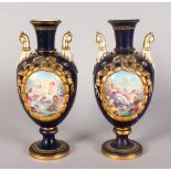 A PAIR OF CONTINENTAL TWO HANDLED VASES, painted with large ovals of classical scenes. 12ins high.