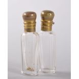 A PAIR OF SMALL GLASS SCENT BOTTLES with metal stoppers. 5cms.