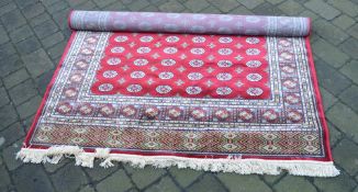 Red ground kashmir rug with a bohkara all over design