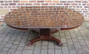 Early Victorian circular/oval draw leaf table on central pedestal with scroll feet & 2 leaves