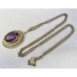 9ct gold pendant with synthetic purple stone on a yellow metal chain