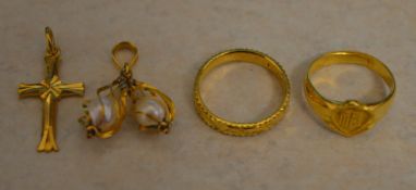 Tested as between 18ct and 22ct gold lot comprising of 2 Oriental rings, a cross and a pendant,