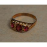 9ct gold ring with a central garnet flanked by imitation stones ,approx weight 1.