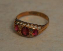 9ct gold ring with a central garnet flanked by imitation stones ,approx weight 1.