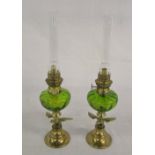 Pair of brass paraffin lamps with green glass reservoir & eagle decoration