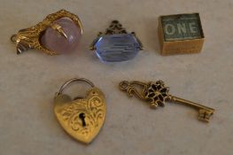 5 9ct gold charms including a key, dragons claw with orb and a swivel fob, total approx weight 16.