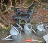 3 galvanized watering cans and a two pairs of garden bench ends
