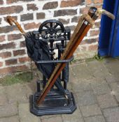 Cast iron stick stand & various walking sticks & an umbrella