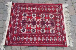Red tribal style rug - approx size 122cm x 94cm