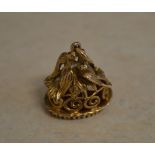 An ornate 9ct gold carnelian fob depicting a pair of doves sitting amongst leaves