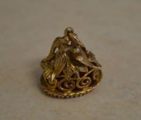 An ornate 9ct gold carnelian fob depicting a pair of doves sitting amongst leaves