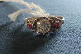 A platinum brilliant cut central diamond ring with ruby and diamond chip ornate shoulders,