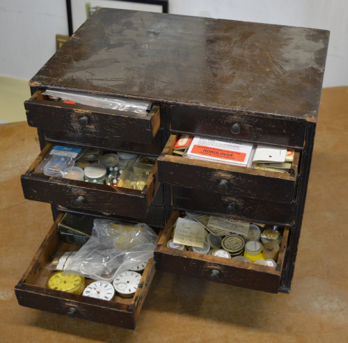 Watchmakers cabinet full of parts, pocket watches,