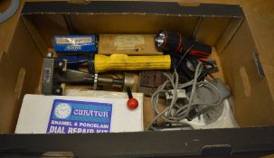 Various watchmakers tools including miniature anvils, magnets, torches,