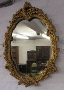 Ornate gilt framed oval wall mirror