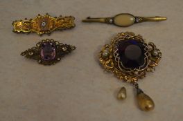 4 yellow metal brooches with synthetic stones