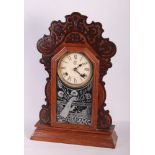 An American carved walnut cased shelf clock, two oak mantel clocks, an oak cased wall clock with