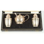 A silver three-piece condiment set, in case, and a pair of silver salt cellars with trefoil tops and