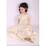 An early 20th Century French doll with composition head and body, articulated limbs, embroidered and
