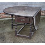 An 18th Century oak oval drop leaf dining table, on bobbin turned supports, 53" long