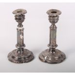 A pair of silver plated extending candlesticks and an Eastern silvered bottle-shaped metal vase