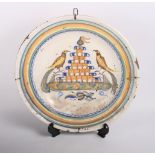 An 18th Century Delft dish, centre painted two birds and tower, 13 1/2" dia