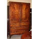 An early 19th Century mahogany linen press, cupboard fitted later shelves enclosed two plain