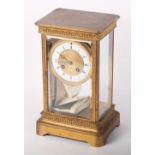 A late 19th Century brass cased four-glass mantel clock with white enamel dial and Roman and