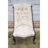 A Victorian button back nursing chair, on scroll carved supports