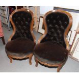 A pair of Victorian walnut framed nursing chairs, upholstered in a dark brown velour