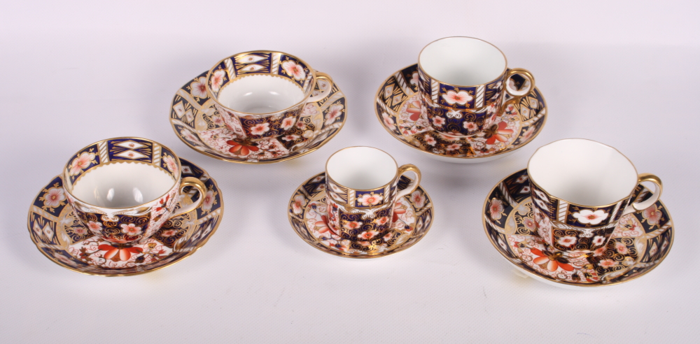 A pair of Crown Derby teacups and saucers, pattern 2451, two similar coffee cups and saucers and a