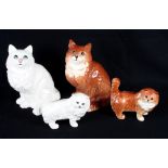 Two Beswick models of seated cats (1867) decorated in white and dark ginger and two similar models