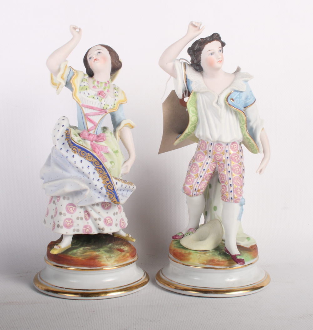 A pair of 19th Century French bisque porcelain dancing figures on circular bases, 9" high