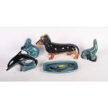 A Beswick model of a dachshund, 9" long, three Poole pottery models of a dolphin, a seal and an