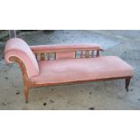 An Edwardian oak chaise longue, upholstered in a pink salmon dralon, on square taper supports, 69"