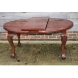 A 19th Century mahogany oval wind-out dining table with centre leaf, on carved ball and claw