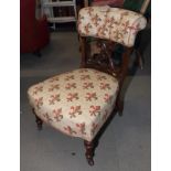 A Victorian nursing chair, top rail and seat button upholstered in a fleur de lis patterned fabric
