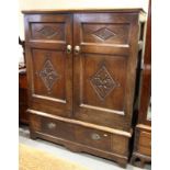 A panelled oak wardrobe of 17th Century design with lozenge panels over one long drawer, 50" wide