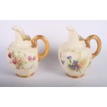 A pair of Royal Worcester blush ivory jugs decorated flowers and gilt handles, 5" high