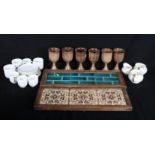 Six brown pottery goblets, a white and gold handled part coffee/tea set and two wooden mounted tiled