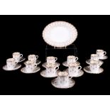 A set of twelve Spode gold fleur de lis pattern coffee cans and saucers and a matching serving dish