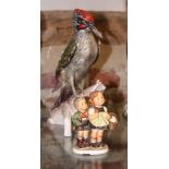 A Goebel ceramic model of a green woodpecker, 11" high, and a Hummel figure of two children